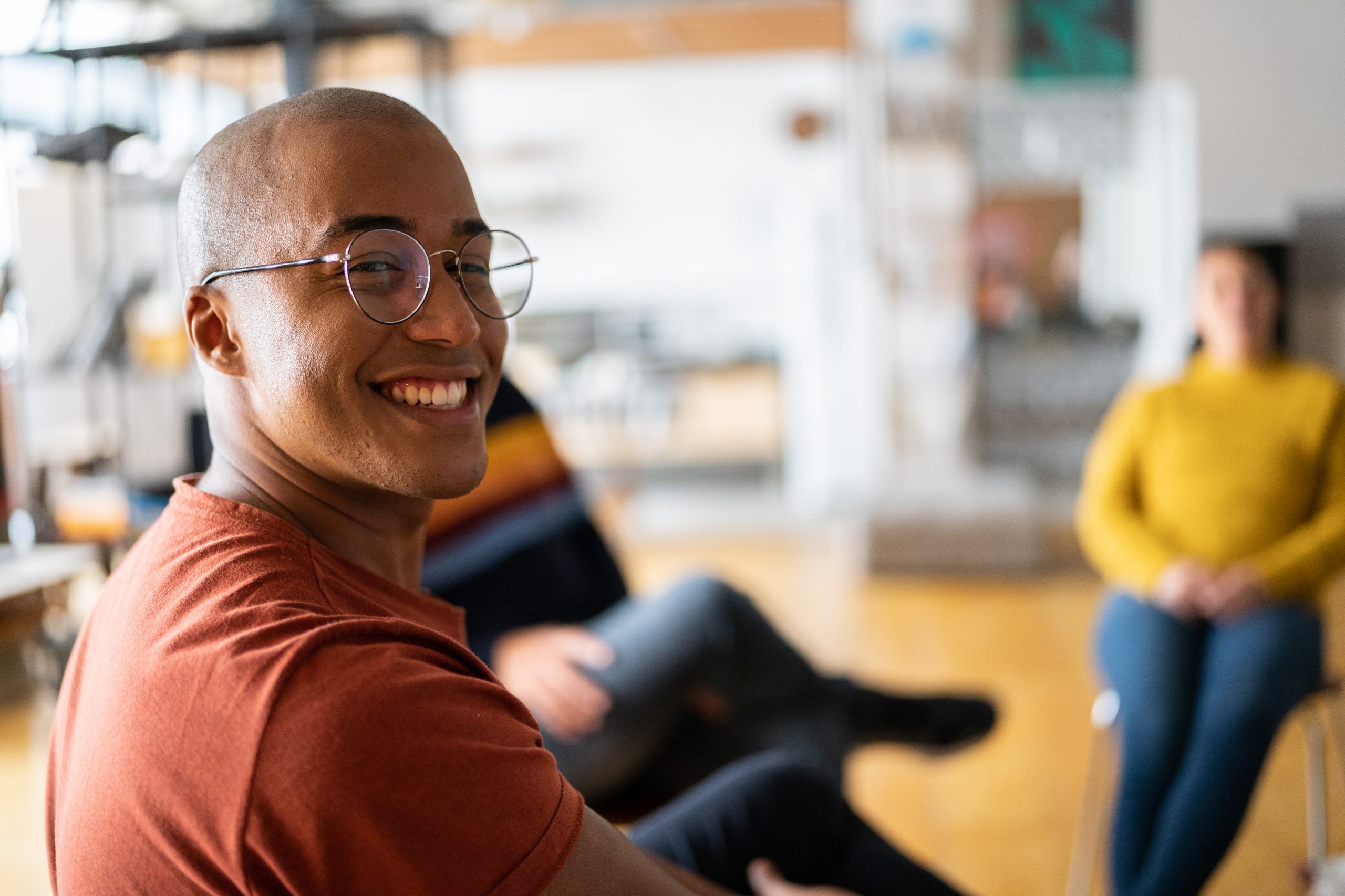 Portrait of a young man in group therapy at a coworking
